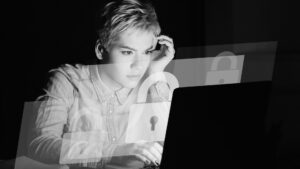 woman looking at laptop with cybersecurity lock icon