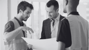 Property maintenance engineers discussing plans with businessman