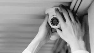 Close up of electricians hands maintaining a CCTV camera